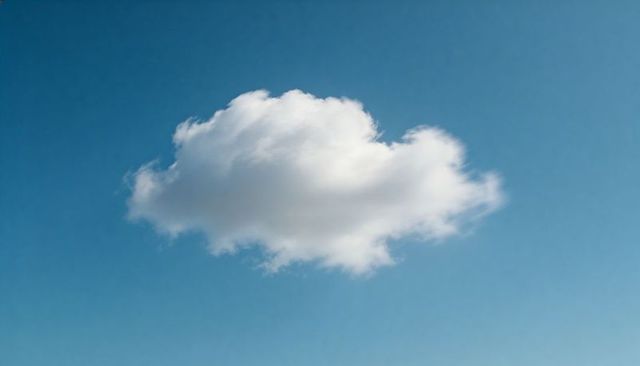 Drifting White Cumulus Cloud Floating Across Clear Blue Sky Minimalist Nature Background