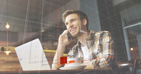 Freelancer working at cafe talking on phone using laptop with red chart analytics overlay