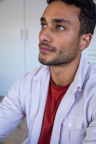 Thoughtful Man Gazing Upward in Contemporary Bedroom