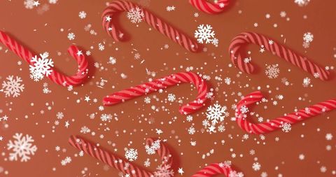Red and White Candy Cane Scatter on Warm Brown Background with Snowflake Confetti