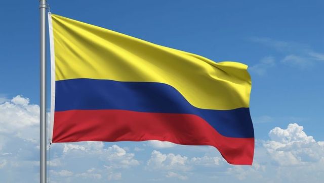 Colombian Flag Waving against Partly Cloudy Blue Sky
