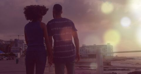 Couple Enjoying Romantic Beach Walk with Light Flare