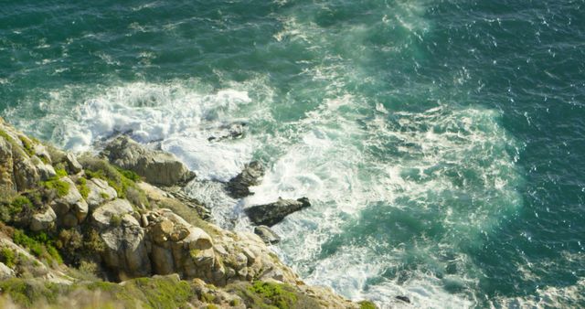 Capturing the power and beauty of waves crashing on a rocky coastal cliff. Perfect for nature, travel, and seascape themes. Great as a background image for websites and posters.