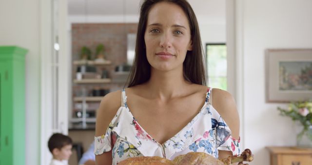 Woman Holding Roasted Turkey in Kitchen, Celebrating Festive Meal Preparation - Download Free Stock Images Pikwizard.com