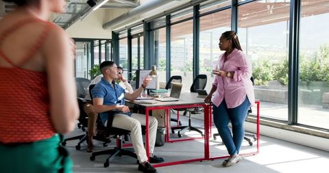 Diverse Team Sharing Ideas in Modern Office Environment