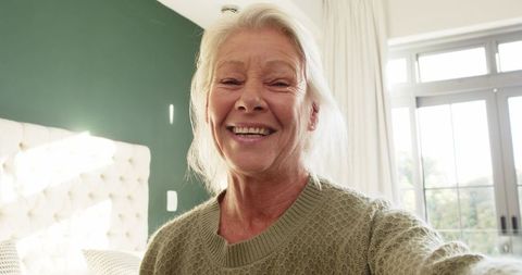 Senior Woman Enjoying Morning Selfie in Modern Bedroom