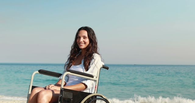 Smiling woman in wheelchair enjoying beach view on sunny day - Download Free Stock Images Pikwizard.com