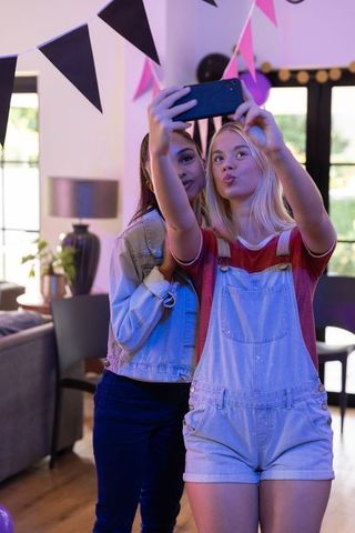 Teenagers taking a selfie during fun home celebration