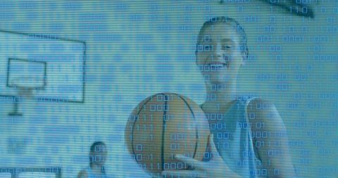 Smiling female basketball player holding ball on indoor court with digital binary overlay