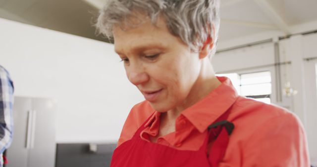 Senior Woman Wearing Red Apron While Cooking in Kitchen - Download Free Stock Images Pikwizard.com