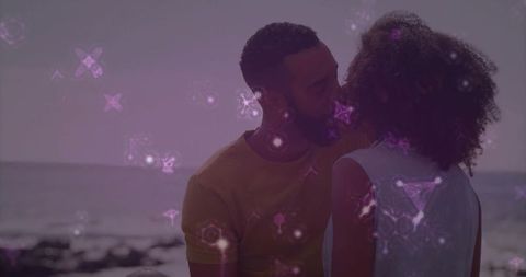 Romantic Couple Kissing and Holding Hands on Beach at Dusk with Purple Geometric Overlay