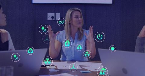 Businesswoman leading sustainability strategy meeting with renewable energy icons
