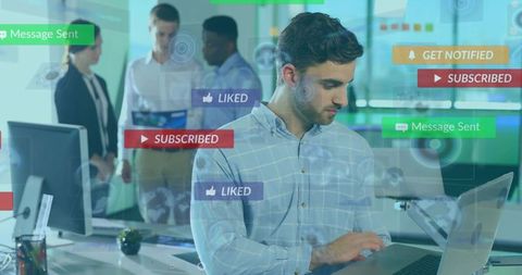 Bearded professional typing on laptop with social media notifications overlay in office