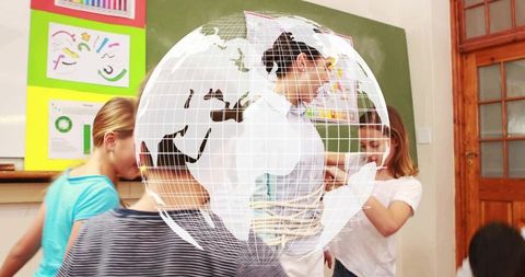 Pointing teacher guiding students in classroom with colorful charts and teamwork