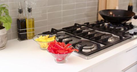 Colorful Pepper Strips present Culinary Versatility Beside Modern Stove