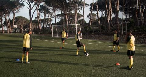 Soccer Players in Yellow Jerseys Practicing on Field
