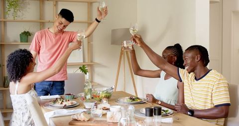 Friends Toasting and Enjoying Lunch Together at the Dining Table