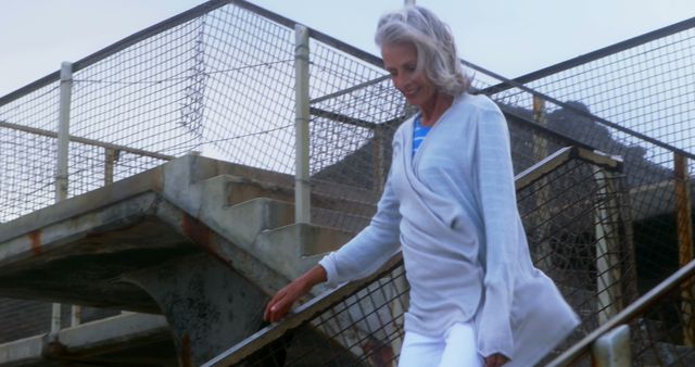 Senior Woman Walking Down Stairs Smiling at Sunny Outdoor Location - Download Free Stock Images Pikwizard.com