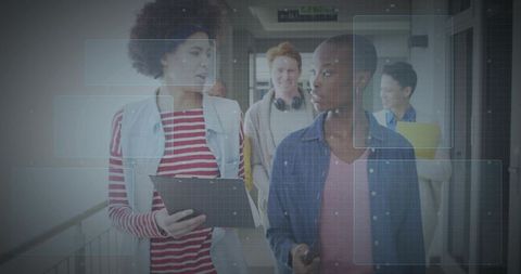 Students walking and collaborating with tablet and smartphone in modern campus hallway