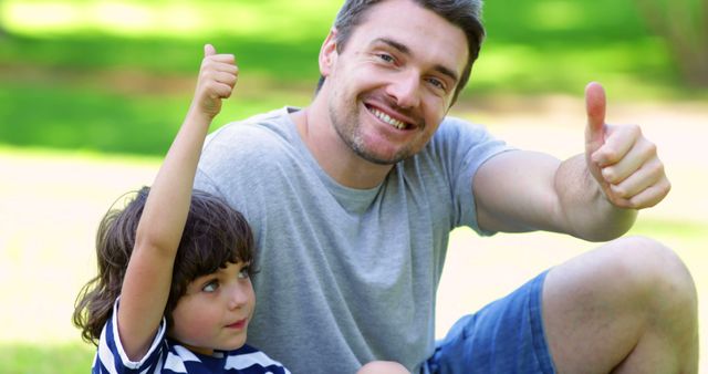 Smiling Father and Son Giving Thumbs Up at Park - Download Free Stock Images Pikwizard.com