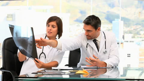 Doctors Analyzing Patient's Scan in Clinical Environment