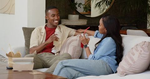 Couple Relaxing with Takeout Drinks on Cozy Sofa at Home