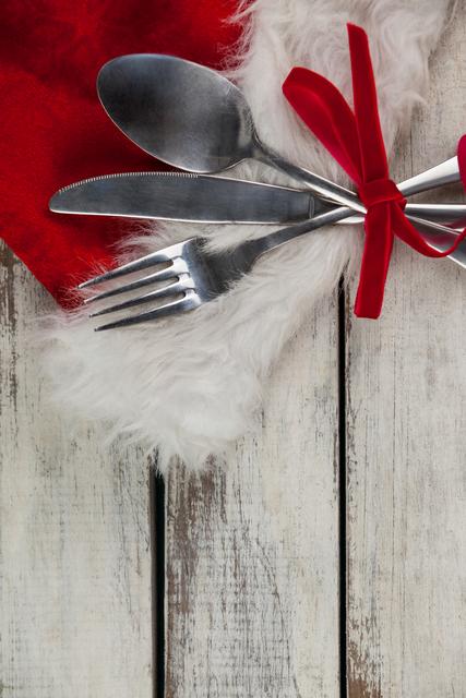 Cutlery tied up with ribbon on a plank