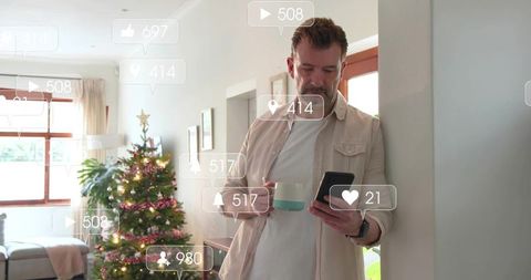 Middle-aged man checking smartphone at home during christmas with notifications