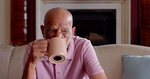 Senior man enjoying hot beverage inside comfortable home