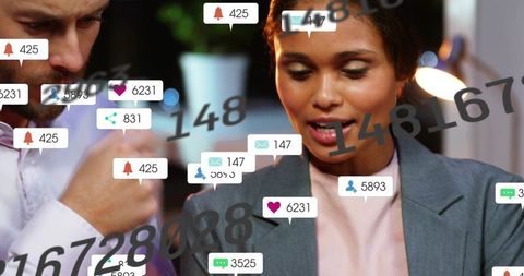 Colleagues reviewing social media notifications and analytics overlay in dim office
