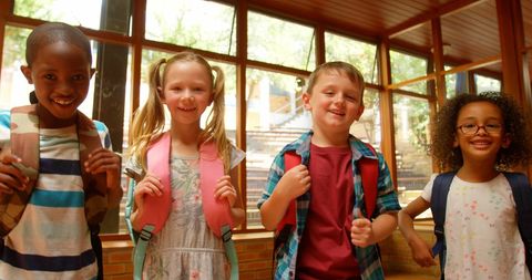 Happy School Children Standing with Backpacks in Corridor - Download Free Stock Images Pikwizard.com