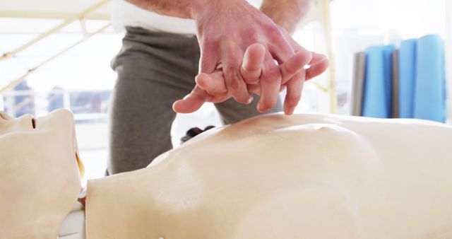 Image shows hands performing CPR on a dummy. Suitable for healthcare training manuals, first aid workshops, CPR certification classes, and medical emergency response materials.