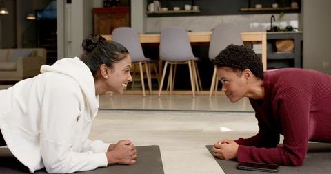 Diverse Women Exercising with Plank Pose in Modern Living Area