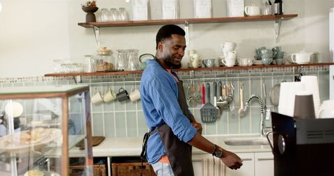 African American Barista Preparing in Cafe with Apron and Blue Shirt