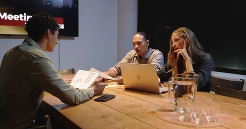 Business Team Collaborating on Project in Evening Meeting