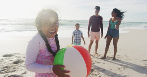 Happy Family Enjoying Beach Activities with Smiling Daughter