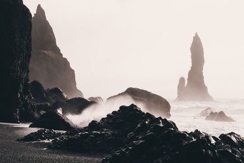 Moody Waves Crashing on Black Volcanic Beach with Jagged Sea Stacks and Mist