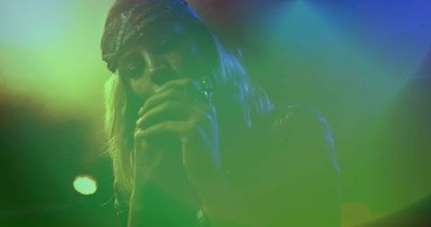 Female Singer Performing on Stage with Colorful Lights