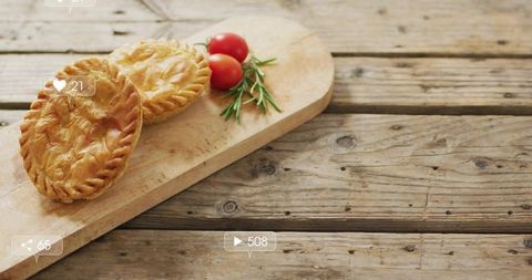 Rustic Hand Pies Sitting on Wooden Board with Cherry Tomatoes and Rosemary