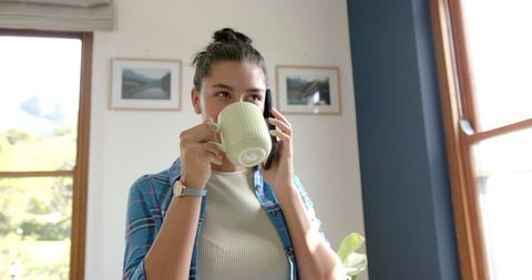 Teenage Girl Chatting on Smartphone While Enjoying Tea at Home