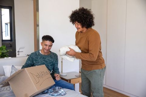 Caring friends packing donation box for charity together