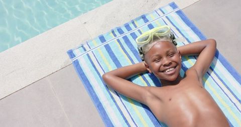 Joyful African American Boy Relaxing by Poolside with Goggles
