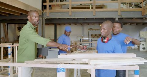 Diverse Woodworking Team Collaborating in Workshop