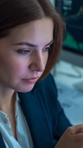 Businesswoman reviewing financial charts on smartphone, vertical video for finance and data