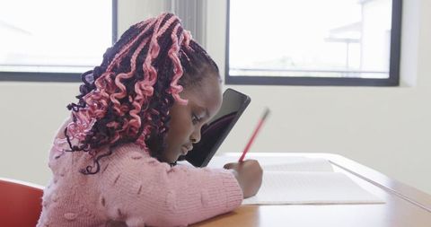 Young Student Studying with Tablet and Notebook at Desk