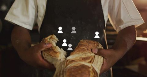 Baker tearing artisan bread with skillful hands