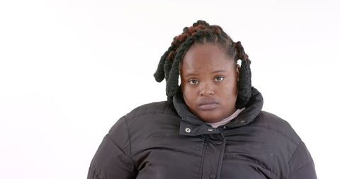 Young Woman in Black Jacket with Reflective Expression on White Background