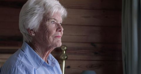 Pensive Elderly Woman Relaxing in Cozy Bedroom Setting