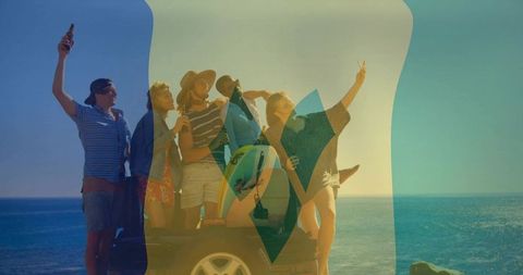 Friends celebrating beach roadtrip posing at coastal overlook with surfboard and drinks