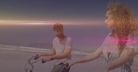 Sunset Coastal Bike Ride: Carefree Romantic Couple Cruising Shoreline with Lens Flare